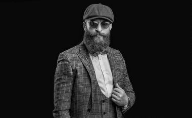 Tepeli şapkalı eski bir gangsterin fotoğrafı. Siyahta izole edilmiş eski bir gangster. Stüdyodaki eski gangster. Arka planda retro gangster adam.