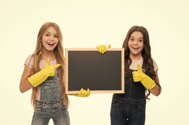 Thumbs up for those whos on duty. Schoolgirls pointing at tidy blackboard. Little girls totally devoted to their school duty. Pupils duty. Having access to education and learning duty, copy space.