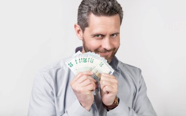 cheerful man with earning money isolated on studio background. man with earning money in studio. man with earning money banknotes. photo of man with earning money.