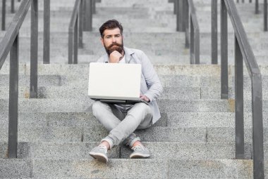 Düşünceli serbest çalışan adamın dışarıda online bilgisayarı var. Serbest çalışan bir adamın sokakta bilgisayar bağlantısı var. Dizüstü bilgisayarı olan serbest çalışan bir adam. Serbest çalışan adamın çevrimiçi bilgisayarı var.