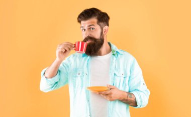 Kafkasyalı, kahve içen, elinde fincan altlığı, sarı arka plan, kafein....