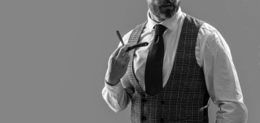 Berber stüdyosunda berberlik yapan adam, fotokopi odası. Sakallı adam berber. Traşsız adam berber bıçağı gri arka planda izole edilmiş. Adam berber bıçağıyla tıraş oluyor..