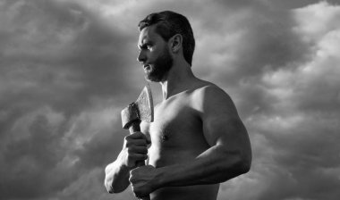 Baltalı üstsüz adam. Beyaz adam, baltayı tut. Arka planda vahşi bir adam. katıksız vahşet.