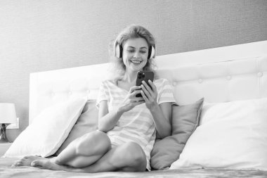 cheerful woman in headphones relax with phone. woman relax at home listen to music in headphones. woman relax listening music.