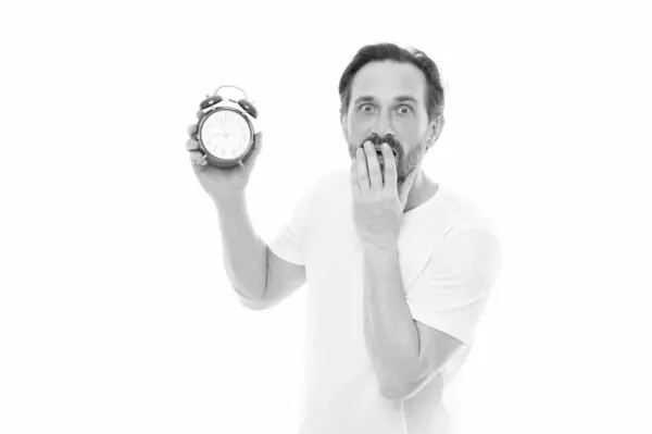 stock image photo of worried man with alarm clock. man with alarm clock isolated on white. man with alarm clock in studio. man with alarm clock on background.