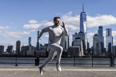 Enerjiyle koşan adam. Spor yaşam tarzı. Sporcu spor paspasıyla koşuyor. Spor adamı eğitimi New York 'ta. Sağlıklı yaşam tarzı ve günlük kondisyon. Spor ve spor. Bir rota çalıştır.
