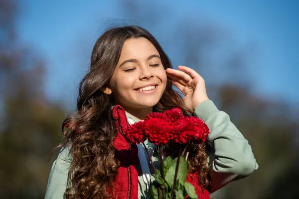 stock image positive teen girl with fall bouquet outdoor. teen girl with fall flowers bouquet. teen girl with fall bouquet outside. photo of teen girl with fall bouquet.