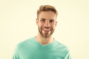 Beyaz arka planda izole edilmiş mutlu, traşsız genç bir adam yüzü. Tişörtlü traşsız bir adamın yüzü. Tıraşsız erkek derisinin portresi. Traşsız bir adamın stüdyo fotoğrafı..