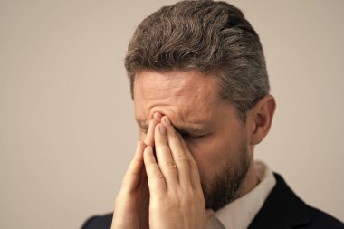 Yorgun adam baş ağrısından muzdarip. İş sorunları. Baş ağrısı migreni. Migreni olan takım elbiseli bir iş adamı. İş adamının ağrısı yüzünden migreni tuttu. İş Kaygısı.