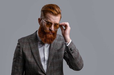 Formalite icabı smokinli adam gride tek başına. Formalite içinde smokin giyen kızıl saçlı adam. Erkekler şık erkek kıyafetleri giyer. Resmi takım elbiseli sakallı beyefendinin zarafeti. Resmi kıyafet. Boşluğu kopyala.