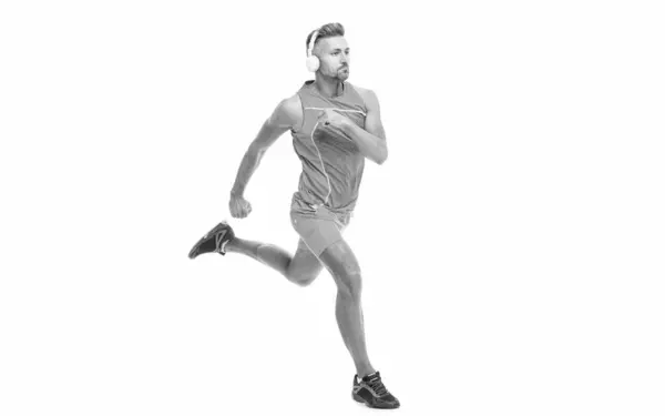 stock image The jogger warmed legs before running. sport jogger listen to music in headphones. The jogger ran at sport training isolated on white. In a morning sport workout jogger run in studio.