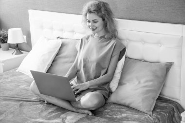 Evde dizüstü bilgisayarla çalışan pozitif kadın. Serbest çalışan bir kadın evde çalışıyor. Serbest çalışan biri için ev işi. Yatakta dizüstü bilgisayarlı bir kadın.