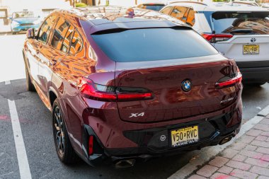 New York City, USA - March 31, 2024: BMW X4 orange car parked outdoor, back view.