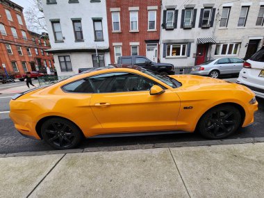 New York, ABD - 10 Mart 2024: 2018 Ford Mustang sarı spor arabası, yan görüş.