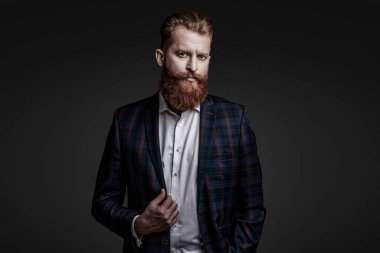 Özel dikim erkek giysisi giymiş sakallı adam. Özel dikim kıyafet giyen bir iş adamı. Şık takım elbiseli bir iş adamı. Resmi terzilik kıyafeti. Erkek giyim kuşamı. Bespoke takımı. Akşam yemeği ceketi.