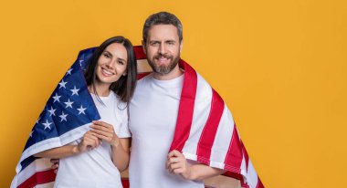 Bayrağa sarılı Amerikalı ruh çifti kutlamak, reklam. Bayrağı olan Amerikalı bir çift. Amerikan bayrağıyla gururla poz veren bir çift. Amerikan bayrağı taşıyan çiftin vatanseverliği.
