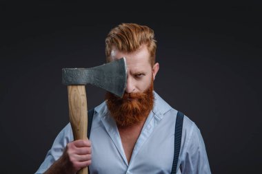 Erkek vahşeti. Antika pantolon askılı, eski tip bir gaddar adam. Siyaha izole edilmiş baltalı askılı vahşi bir adam. Saçları kızıl saçlı, olgun bir adam. Acımasız erkek modası. Gerçek adam..