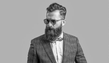 Arkadaki yakışıklı smokinli resmi adam. Smokin giymiş sakallı bir adamın resmi. Smokinli resmi adam Griler 'de izole edilmiş. Smokinli resmi adam stüdyoda..