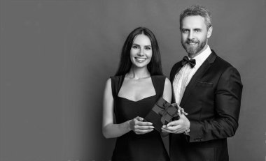 Aşk çifti reklam pankartıyla kırmızıda izole edildi. Aşk çifti stüdyoda. Arka planda mevcut aşk çifti. hediye kutulu aşk çifti fotoğrafı..