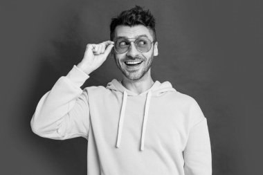 Stüdyodaki havalı adama hayran kaldım. Gözlüklü havalı bir adam. Havalı adamın fotoğrafı. Kırmızı arka planda izole edilmiş havalı adam.