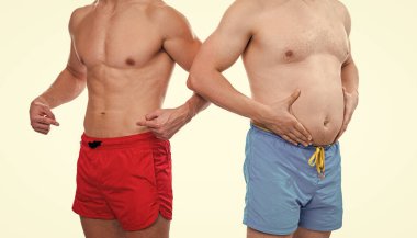 Göbek karın kasları karşılaştırması yapan erkeklerin kırpılmış görüntüsü. Karın kası olan erkeklerin fotoğrafı. Karın kasları beyazda izole edilmiş erkekleri karşılaştırıyor. Stüdyodaki erkeklerin karın kası karşılaştırması..
