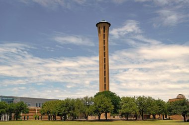 Mimari kule simgesi. Dallas Üniversitesi kampüsünün dışındaki kulede. Dallas Üniversitesi Mimarisi. Üniversite kampüsünde yüksek bina.