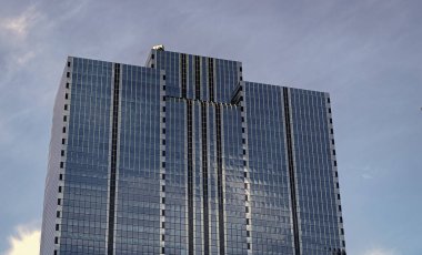 Camsı yüzlü bir gökdelen. Modern cam bina. Metropolis City 'de bir gökdelen. Şehir merkezinde gökdelenli bir şehir. İş yerindeki ofis binası. Gökdelen mimarisi. modern şehir.