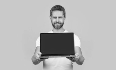 Laptopta uygulamayı gösteren seçici odaklanma. Adam ekranda kopyalama alanı ile uygulama gösteriyor. Sarı arka planda izole edilmiş uygulamayı gösteren adam. Stüdyoda dizüstü bilgisayar uygulaması gösteren adam.