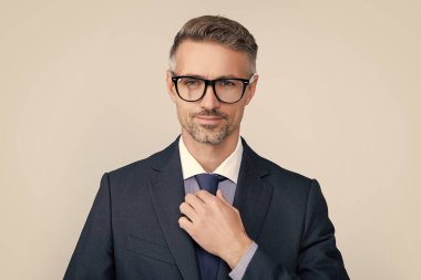 Gülümseyen, resmi takım elbiseli olgun bir adam..