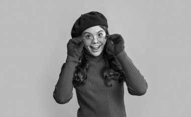 Esmer saçlı, şaşkın bir genç kızın fotoğrafı. Fransız genç kız sarı arka planda izole edilmiş. Stüdyodaki Fransız genç kız. Genç Fransız kız..