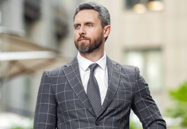 Ceketli patronun portresi. Kafkasyalı patron dışarıda bekliyor. Profesyonel giyim patronu. Yetişkin patron dışarıda.