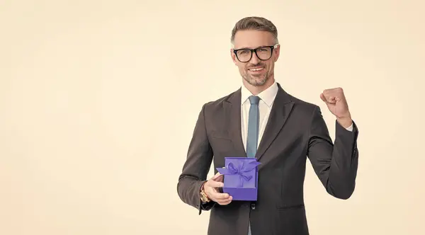 stock image successful mature man in eyeglasses and suit hold present box isolated on white background.