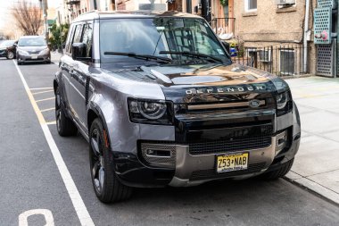 New York City, ABD - 1 Nisan 2024: 2020 Land Rover Defender L663 SUV arabası caddeye park edilmiş, köşe manzaralı.