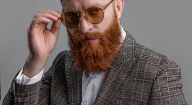 Resmi kıyafet. Formalite icabı smokinli adam gride tek başına. Formalite içinde smokin giyen kızıl saçlı adam. Erkekler şık erkek kıyafetleri giyer. Resmi takım elbiseli sakallı beyefendinin zarafeti. Görkemli zarafet.