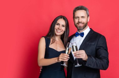 Aşık çift nişanı kutluyor. Zarif çift kırmızıda izole edilmiş şampanya içer. Resmi olarak bir çift. Romantik randevu kutlamaları. Sevgililer Günü reklamı. Yıldönümünü kutla.