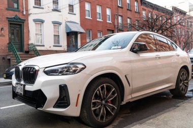 New York City, ABD - 1 Nisan 2024: BMW X4 lüks geçiş aracı açık hava, köşe manzaralı.