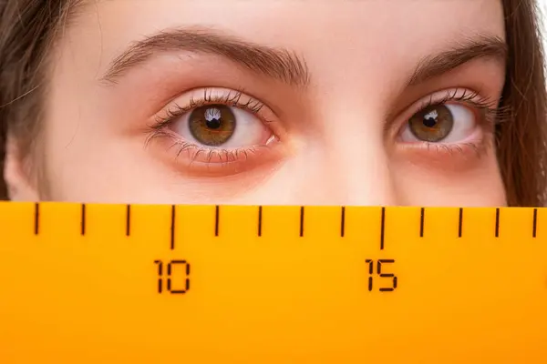 stock image Girl student eye with ruler. Time to study. Knowledge of geometry. School education. Measuring mathematics tool. Teen girl back to school. Math and mathematics. Education and knowledge. Closeup.