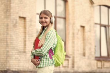 school education of cheerful teen girl in the street. photo of school education of teen girl with backpack. school education of teen girl outdoor. school education of teen girl outside.