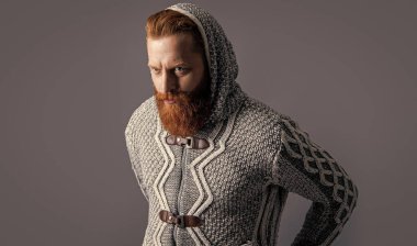 Sıkı örgü giymiş vahşi bir adamın görüntüsü. Gri örgü ören vahşi adam izole edilmiş. Stüdyoda örgü ören vahşi bir adam. Arka planda sıkı örgü ören vahşi adam..