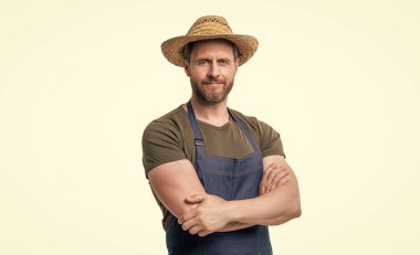 smiling caucasian gardener in hat and apron isolated on white background.