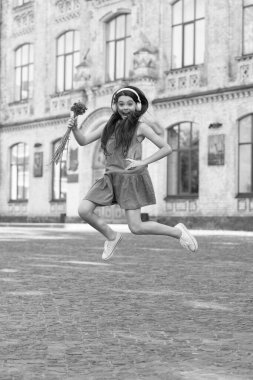 glad teen girl in headphones. girl jump outdoor. carefree girl jumping feel happiness.