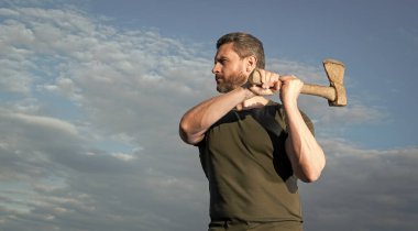man with axe. caucasian man hold ax. brutal man on sky background with copy space.