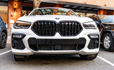 New York City, ABD - 15 Mart 2024: BMW X6 modern beyaz araba açık hava, alçak görüş.