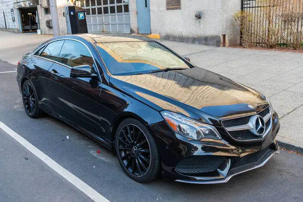 New York City, ABD - 15 Mart 2024: 2014 Mercedes Benz E550 lüks araba açık hava, köşe manzaralı.