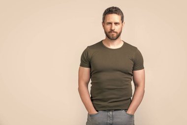 caucasian guy with stubble isolated on grey background, copy space. caucasian guy with stubble in studio. photo of caucasian guy with stubble. caucasian guy with stubble wear tshirt.