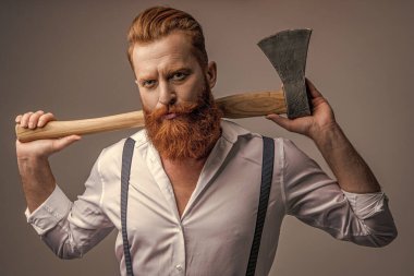 caucasian masculine man with axe in studio. masculine man with axe on background. photo of masculine man with axe. masculine man with axe isolated on grey.