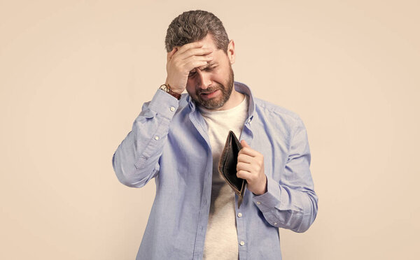 frustrated poor man with wallet at hand. photo of poor man with wallet. poor man with wallet isolated on studio background. poor man with wallet in studio.