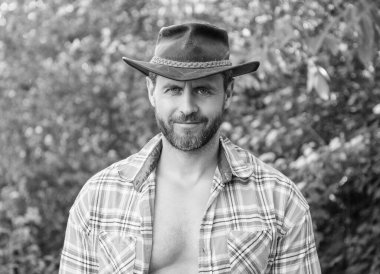 Kovboy şapkalı, maço gülümseyen adam. Kareli gömlekli maço adam. Batılı maço şapkalı adam..