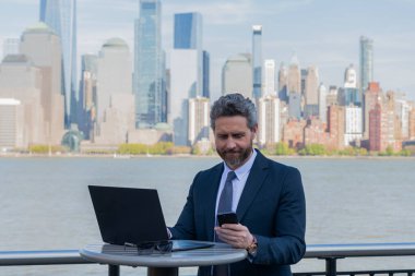 İnternette çalışan bir iş adamı. İş adamı dışarıda dizüstü bilgisayarla çalışıyor. Adam internet tarayıcısından iş e-postası ve sörf yolluyor. Dijital veri yönetimi. New York 'ta serbest çalışan bir iş adamı. Uzak çalışma.