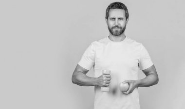 Sağlıklı meyveli fitness adamı sarıda izole edilmiş, reklam. Arka planda sağlıklı meyveleri olan fitness adamı. Stüdyoda sağlıklı meyveli fitness adamı. Sağlıklı elmalı fitness adamı fotoğrafı.